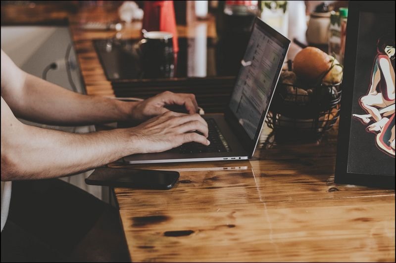 person-in-front-of-laptop-on-brown-wooden-table-2115217 想撿便宜買點數?小心中了「代儲詐騙」的圈套